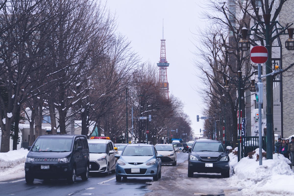 Sapporo snowy street with cars and Sapporo TV Tower in winter