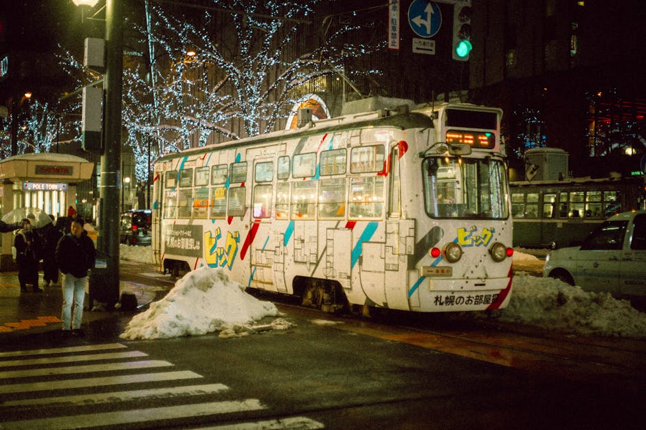 Tram traveling through snowy urban street at night