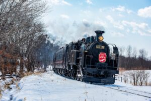 Steam train traveling through snowy winter landscape in Hokkaido