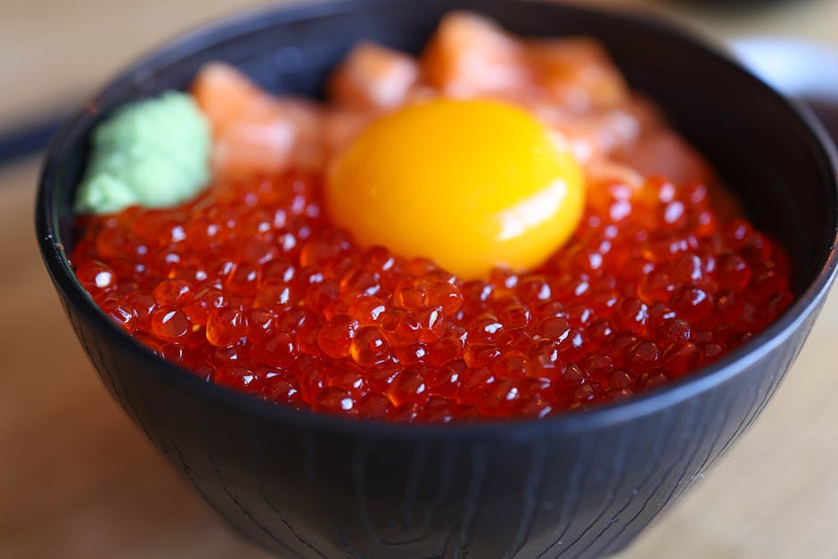Close-up of ikura donburi with salmon roe, egg yolk and wasabi