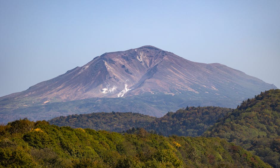 Volcanic mountain rising above forested landscape in Hokkaido Japan