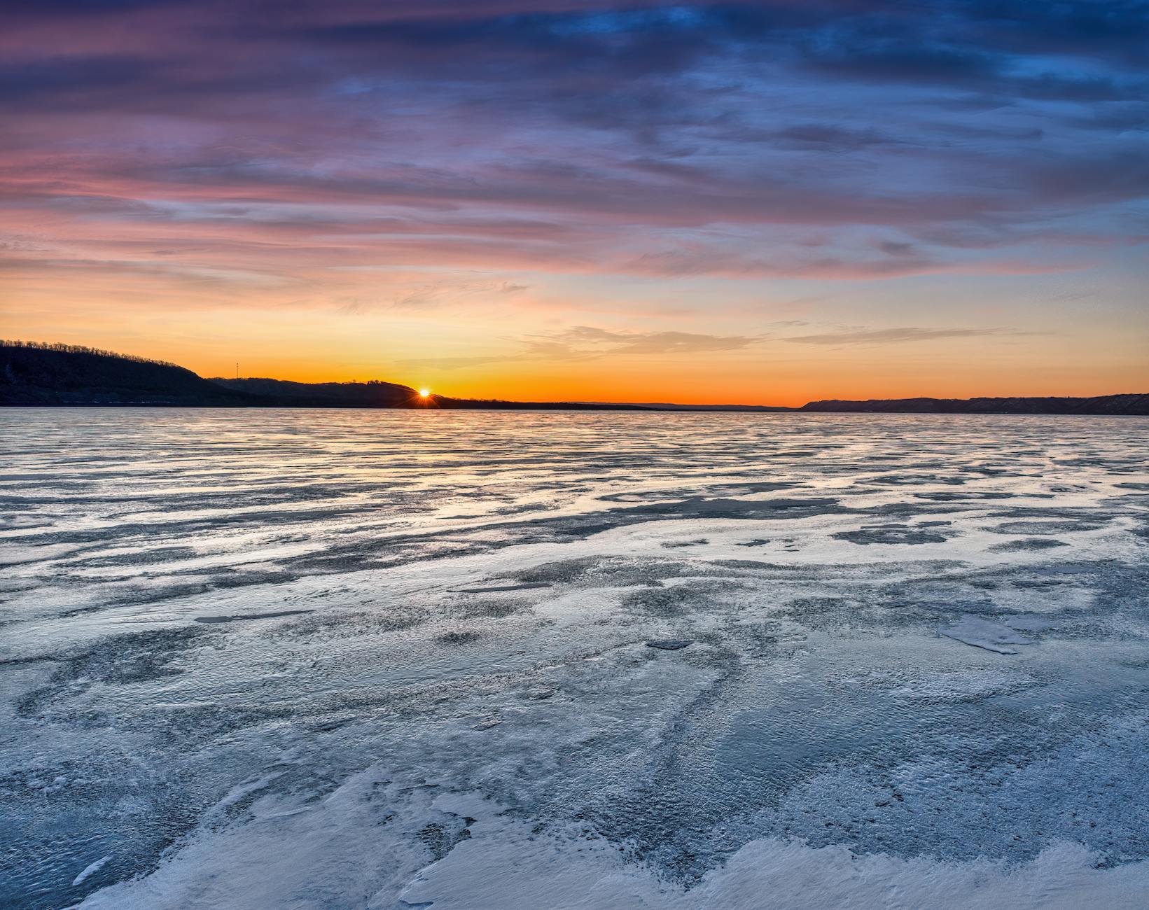 Frozen lake with dramatic sunset colors in winter