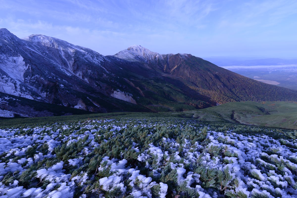 Snowcapped mountains with lush green valleys in Hokkaido