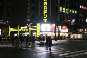 Nighttime street in Sapporo, Hokkaido with illuminated storefronts and pedestrians