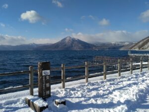 Snow-covered shore of Lake Shikotsu with mountains in the background, Hokkaido
