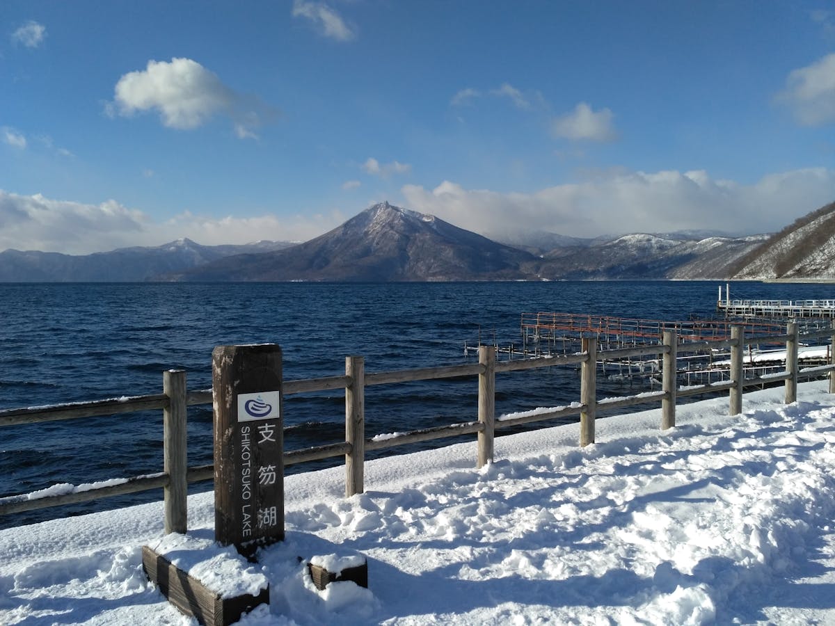Snow-covered shore of Lake Shikotsu with mountains in the background, Hokkaido