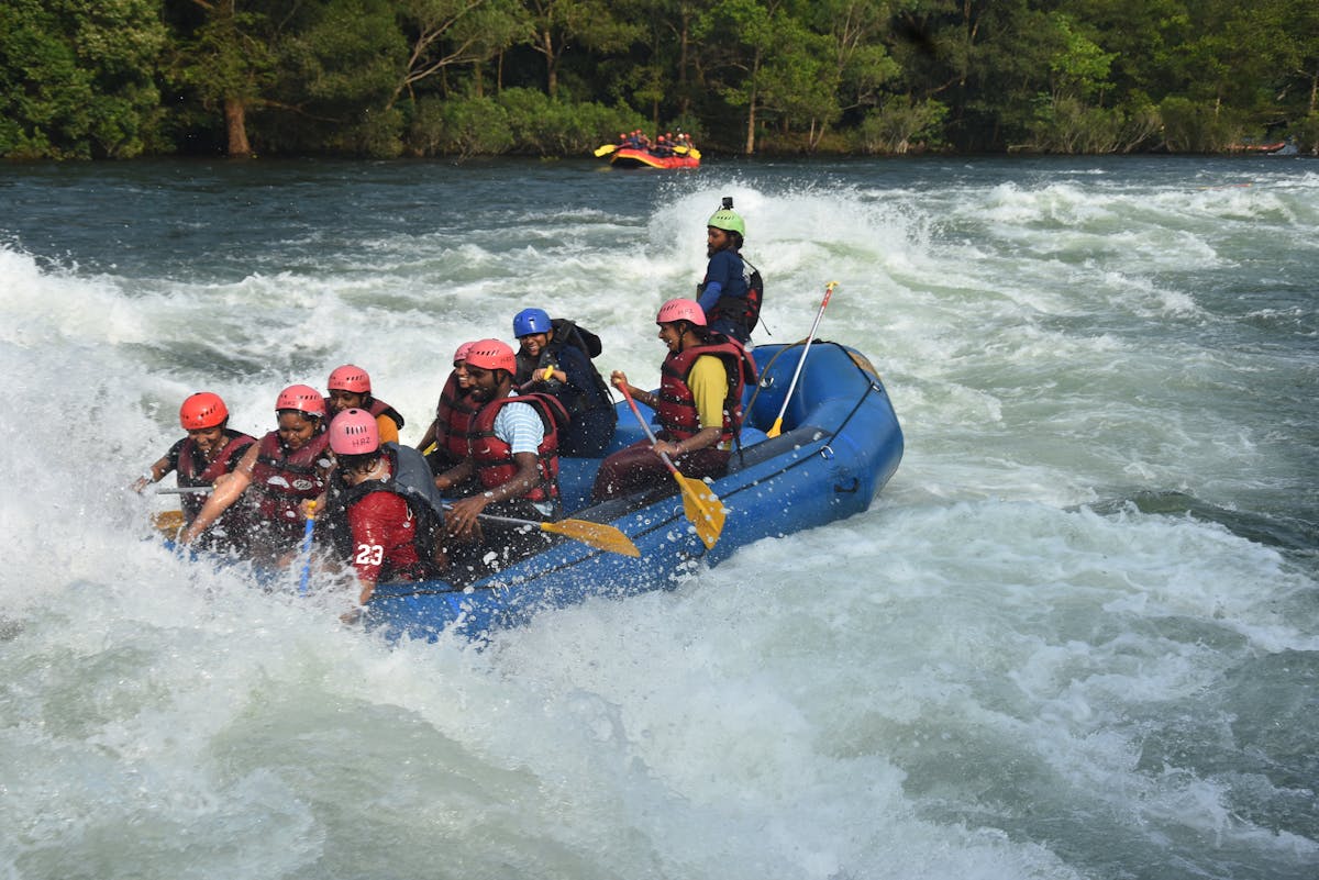 Group of people river rafting through rapids