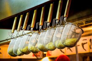 Close-up of noodle strainers hanging in a Japanese ramen restaurant