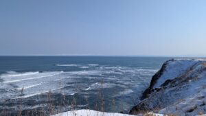 Snow-covered cliffs along Cape Shiretoko with ocean waves in winter