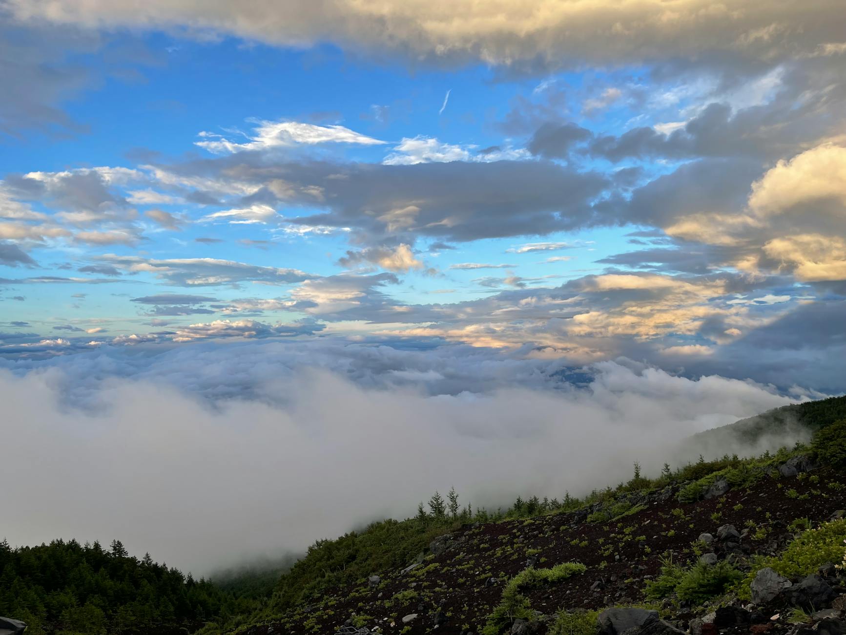 Sea of clouds viewed from a mountain terrace with peaks emerging through the mist